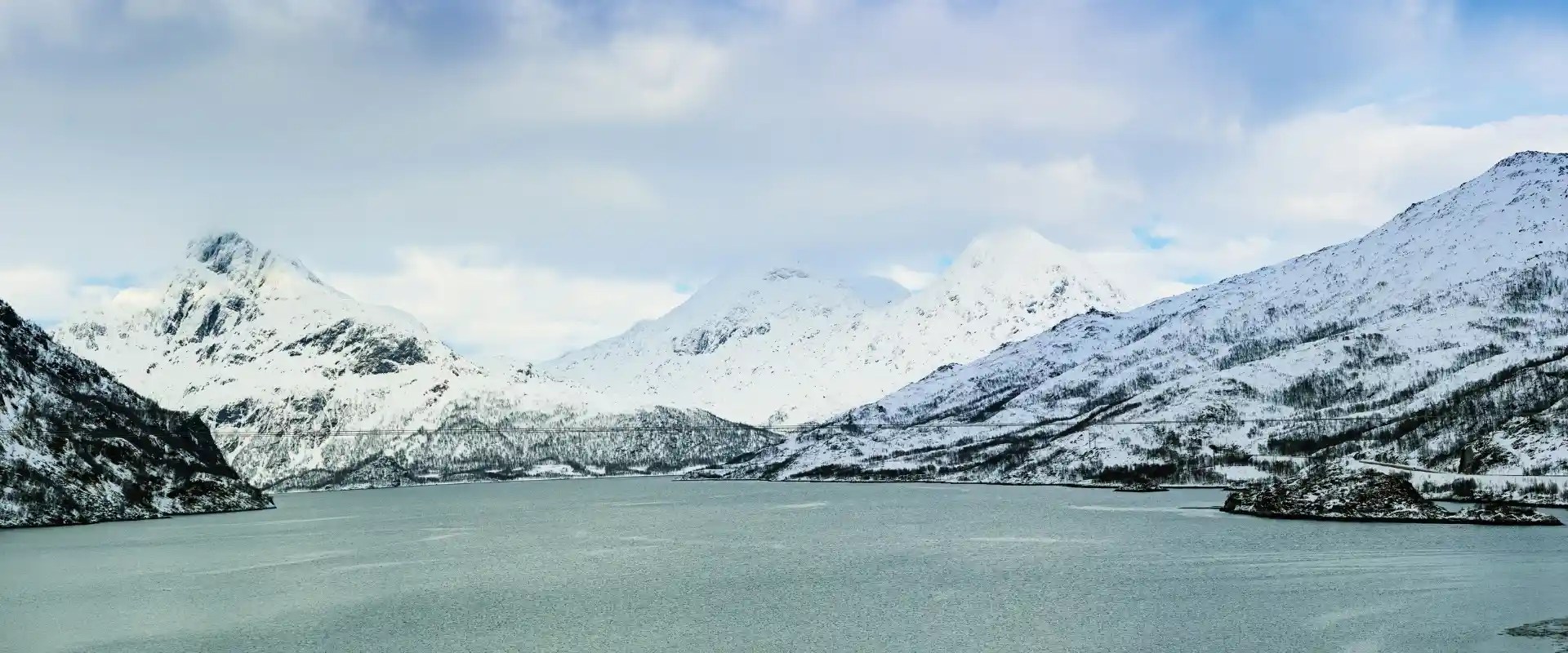Utsikt over hav og hvite fjell